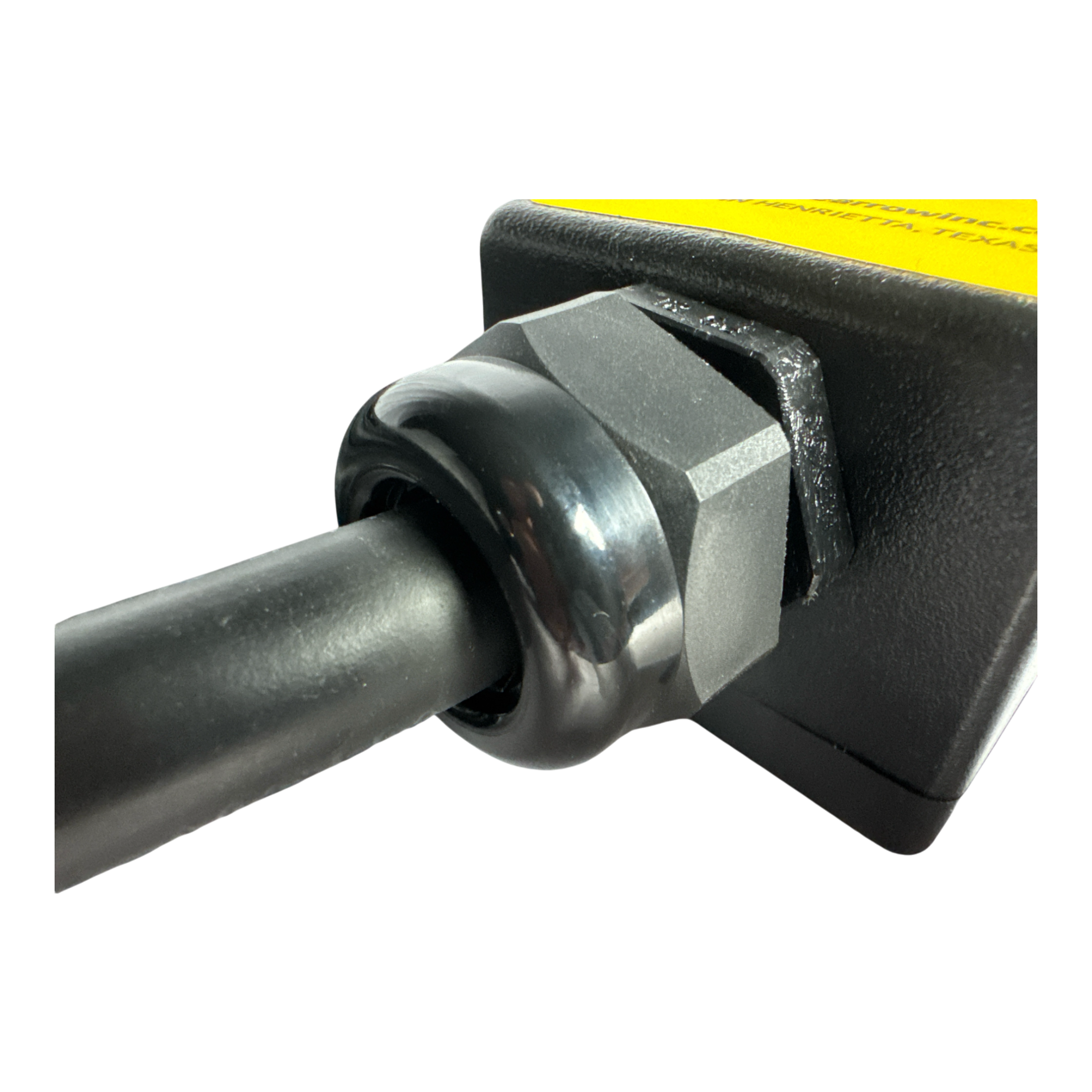 Close-up of a cable connected to the PIERCE 8 Function Wrecker Remote, a black and yellow device with a hexagonal nut, commonly used in solenoid systems in the towing industry.