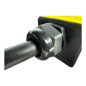 Close-up of a cable connected to the PIERCE 8 Function Wrecker Remote, a black and yellow device with a hexagonal nut, commonly used in solenoid systems in the towing industry.