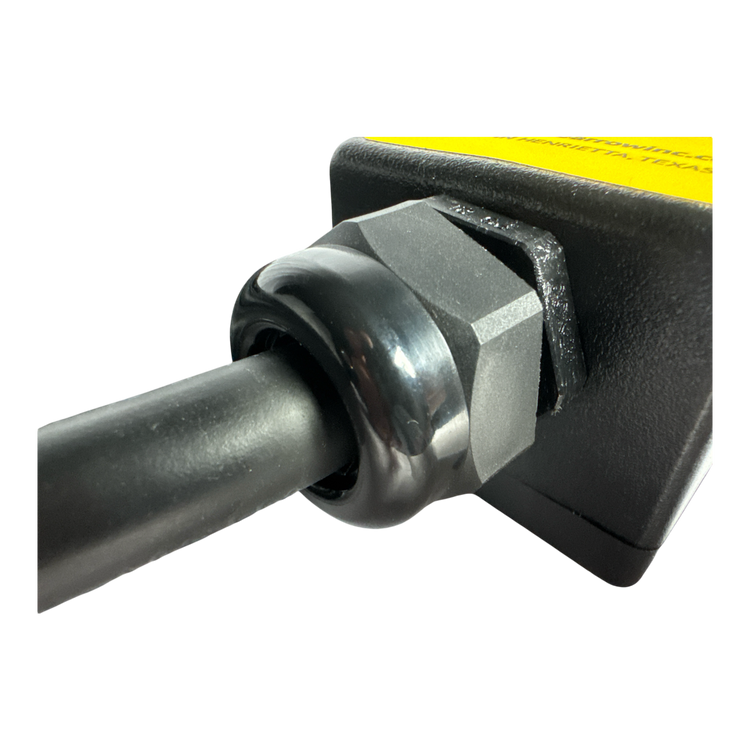 Close-up of a cable connected to the PIERCE 8 Function Wrecker Remote, a black and yellow device with a hexagonal nut, commonly used in solenoid systems in the towing industry.