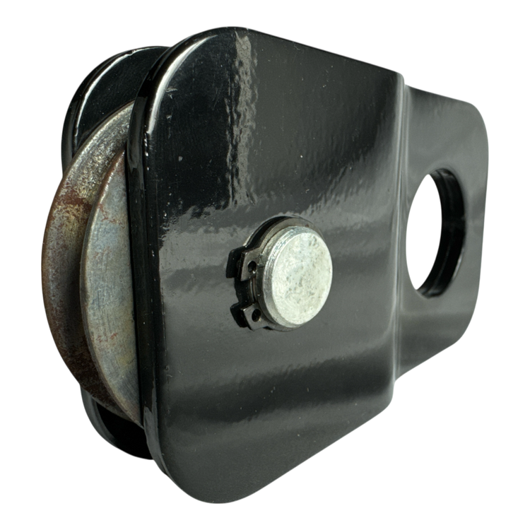 Close-up of a PIERCE Snatch Block WLL 6,000 lbs. featuring a circular metal wheel on a black background.